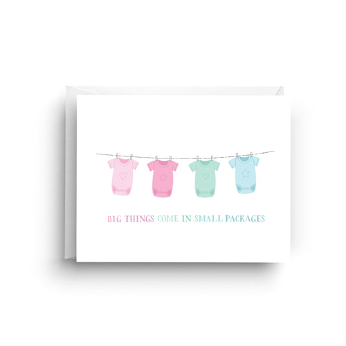 Card with baby clothes on a line and text 'Big things come in small packages' on a white background