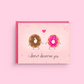 Card with cartoon donuts and text 'i donut deserve you' on a pink background