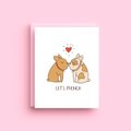 Greeting card with two dogs kissing and a heart above them on a pink background
